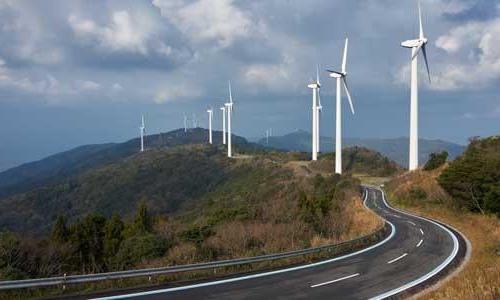 A road winding through 风力涡轮机